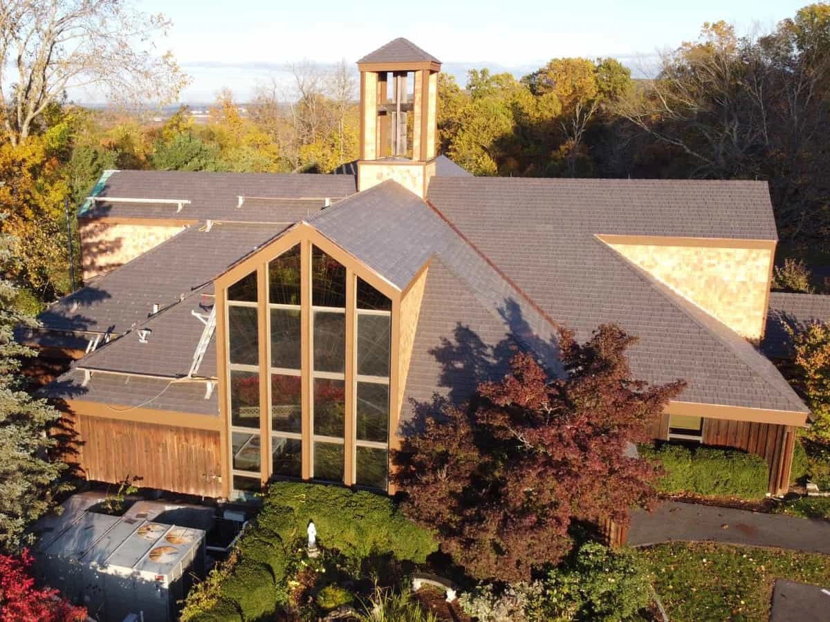 Enviroshake composite cedar shake roofing on a large church surrounded by mature trees and autumn foliage.