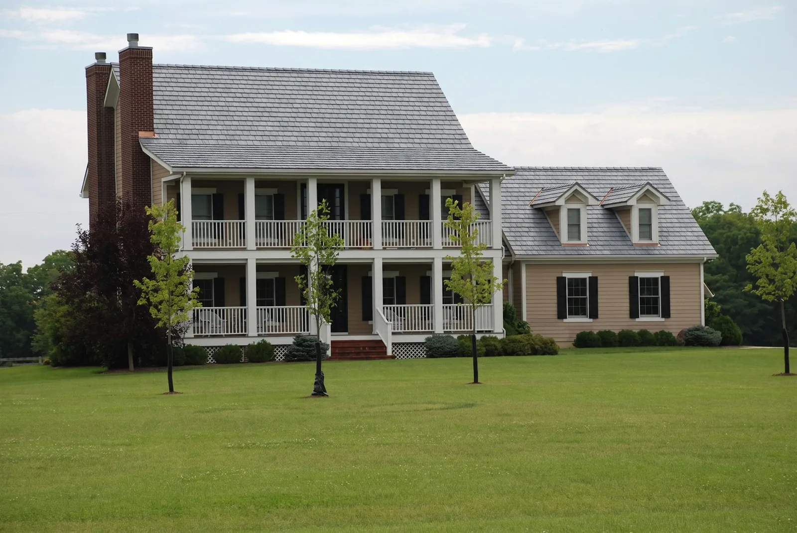 White colonial home with a gray synthetic cedar shake roof