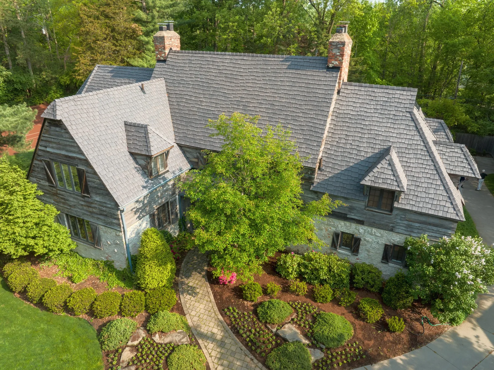 Aerial view of a stone home with a gray Enviroshake synthetic cedar shake roof