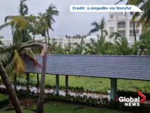 Wind-damaged tropical property with an intact gray Enviroshake covered walkway