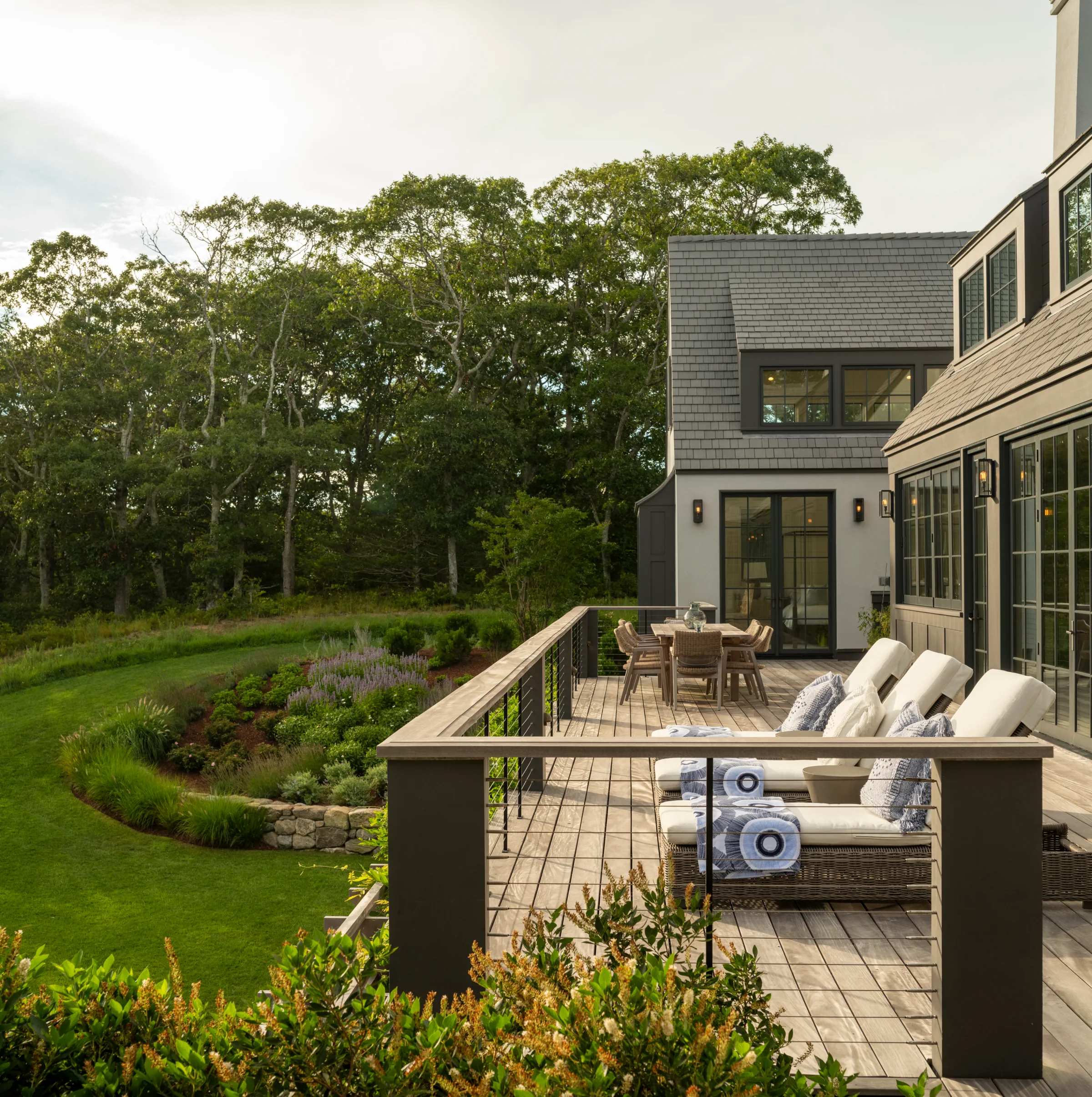 Stone and shingle home with an outdoor patio and Enviroshake roof overlooking gardens