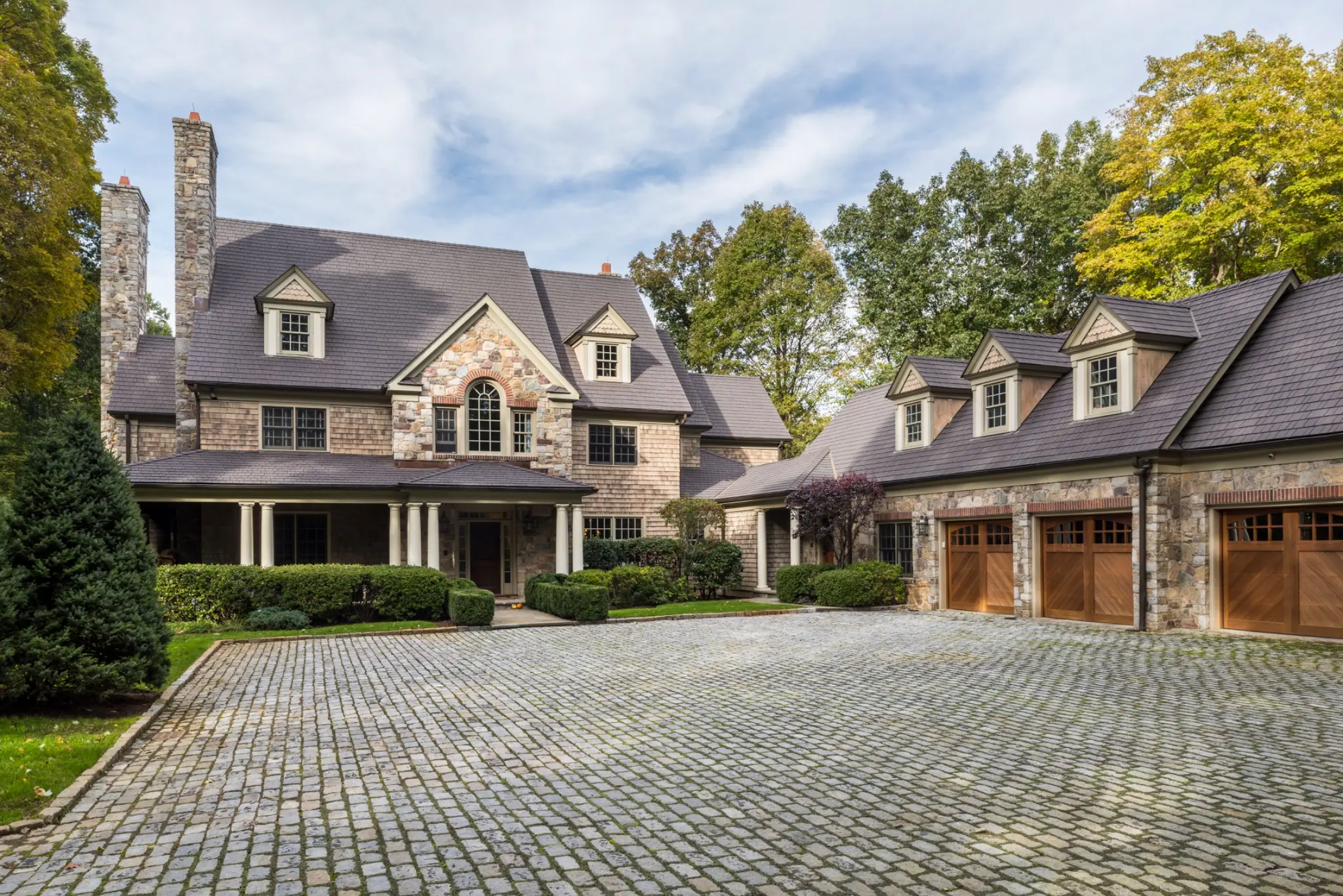 Stone home with an Enviroshake Aged Cedar roof and cobblestone driveway