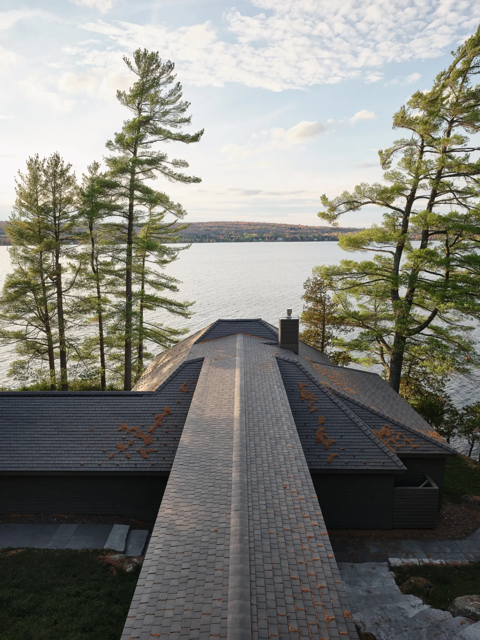 Enviroshingle roof on a modern lakefront home with a glass walkway among pine trees