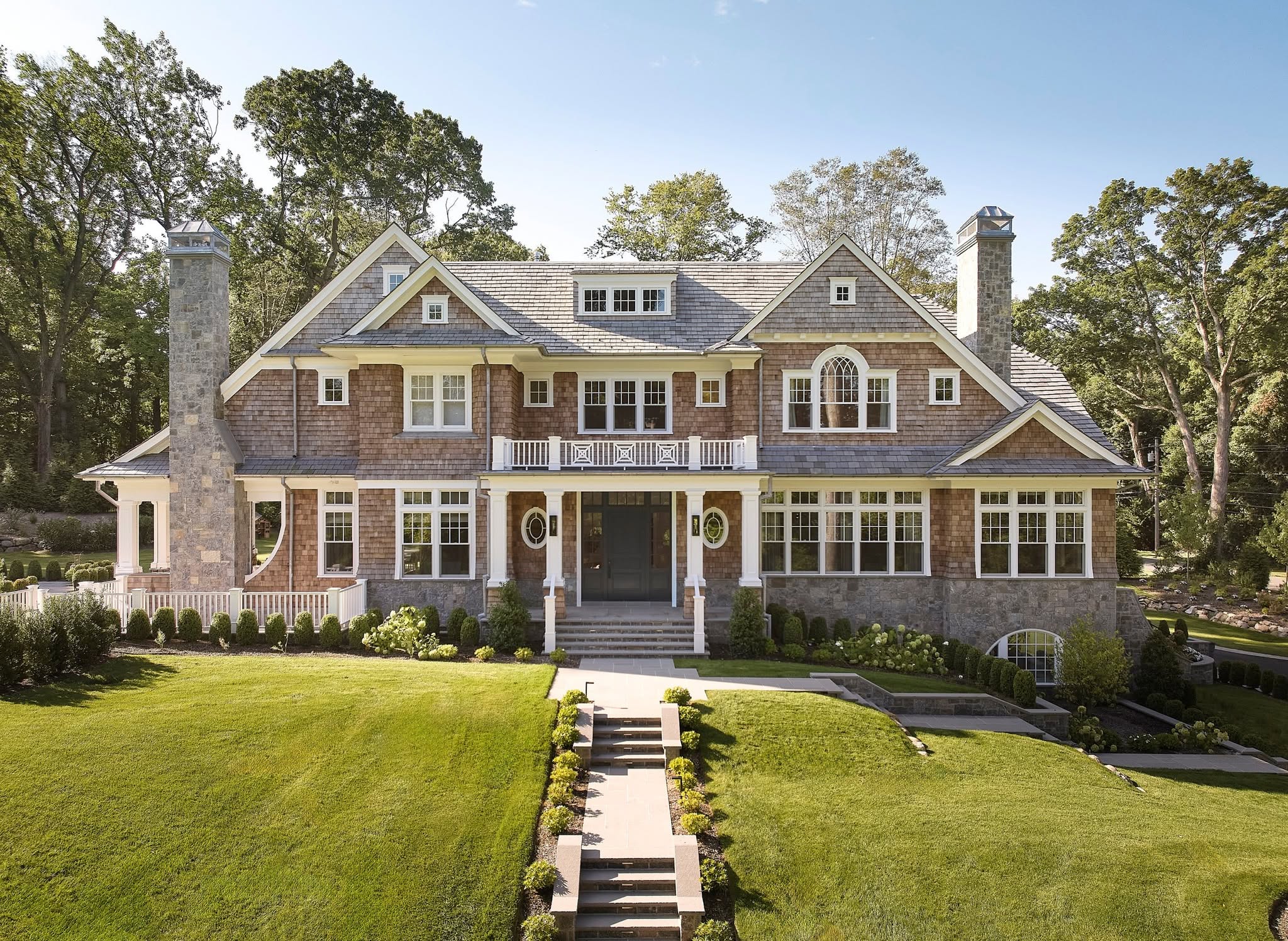 Shingle-style estate home with an Enviroshake roof above a terraced lawn