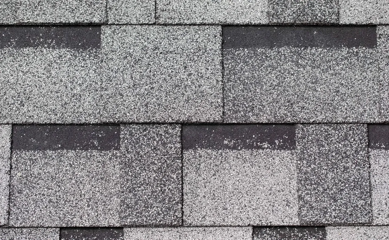A closeup swatch of grey standard 3-tab asphalt shingles