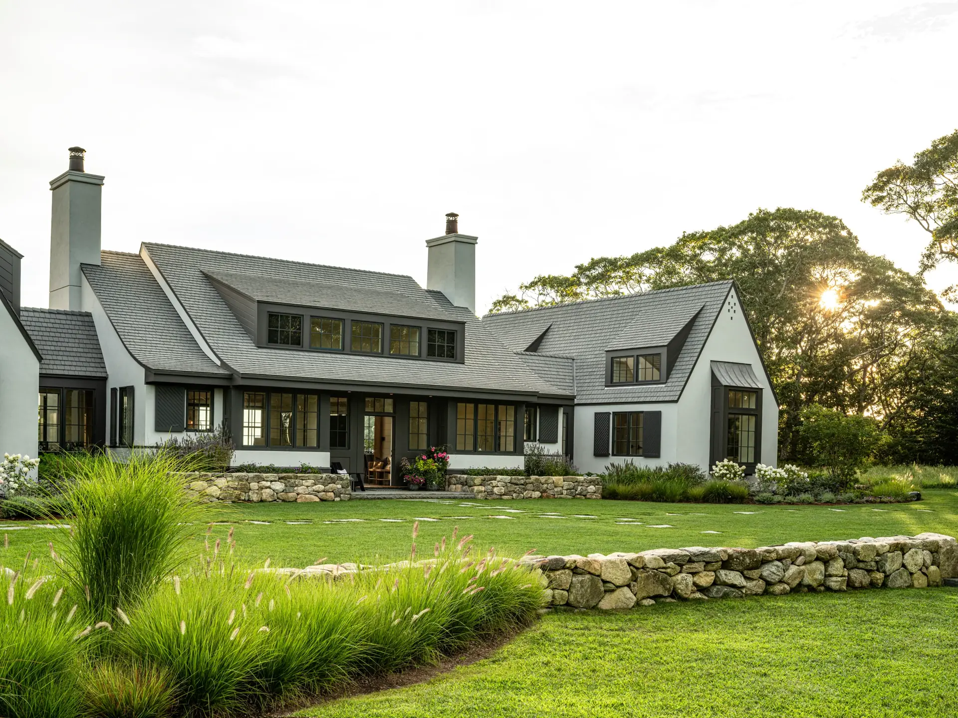 Coastal home with an Enviroshake roof and a wide lawn at dusk