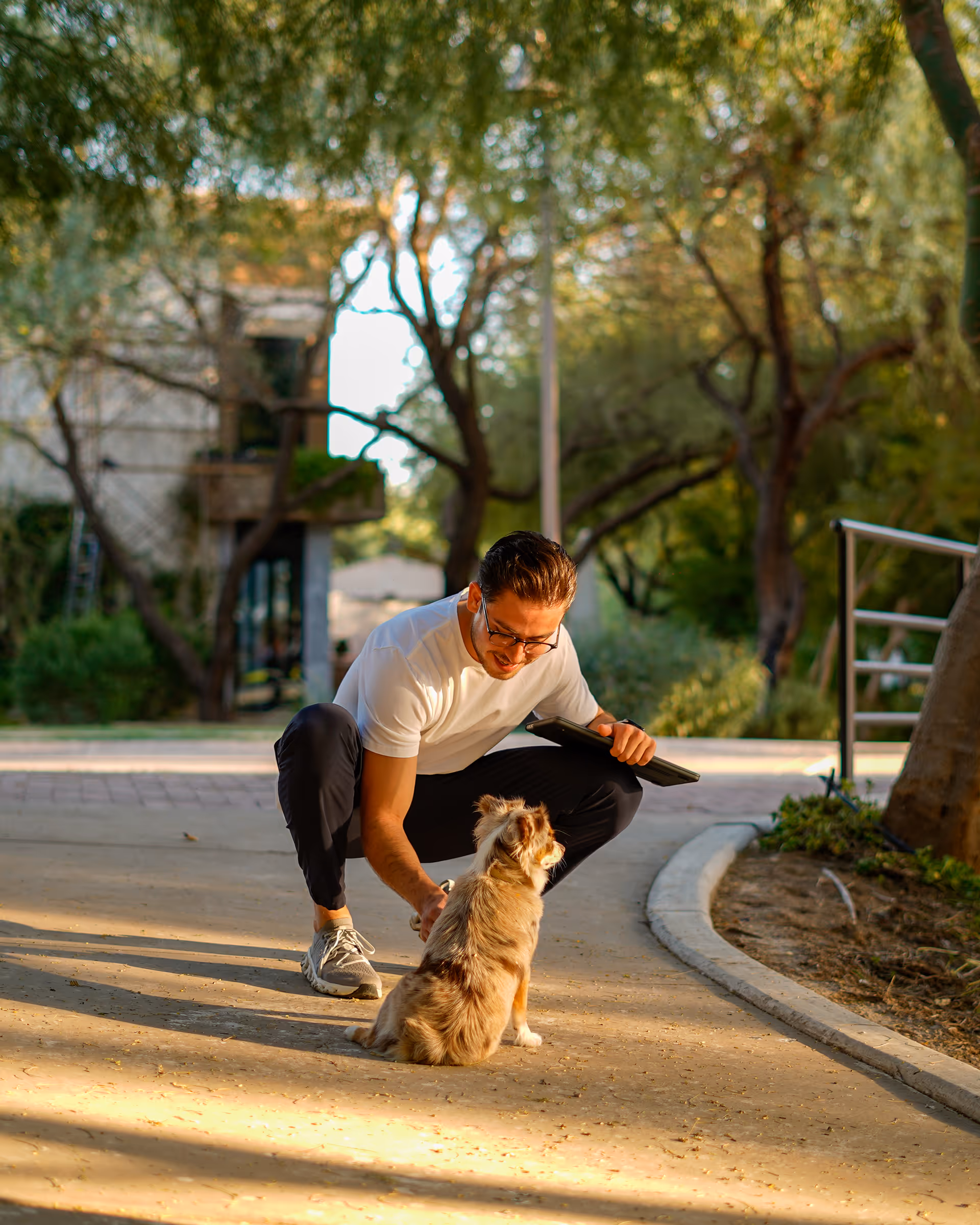 Hombre jugando con su mascota al aire libre en un espacio verde de Las Riberas