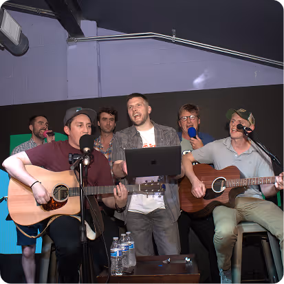 A group of men singing and playing guitars.