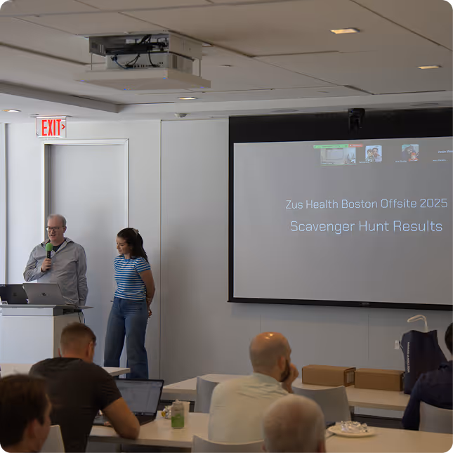 A group of people standing in front of a projector screen.