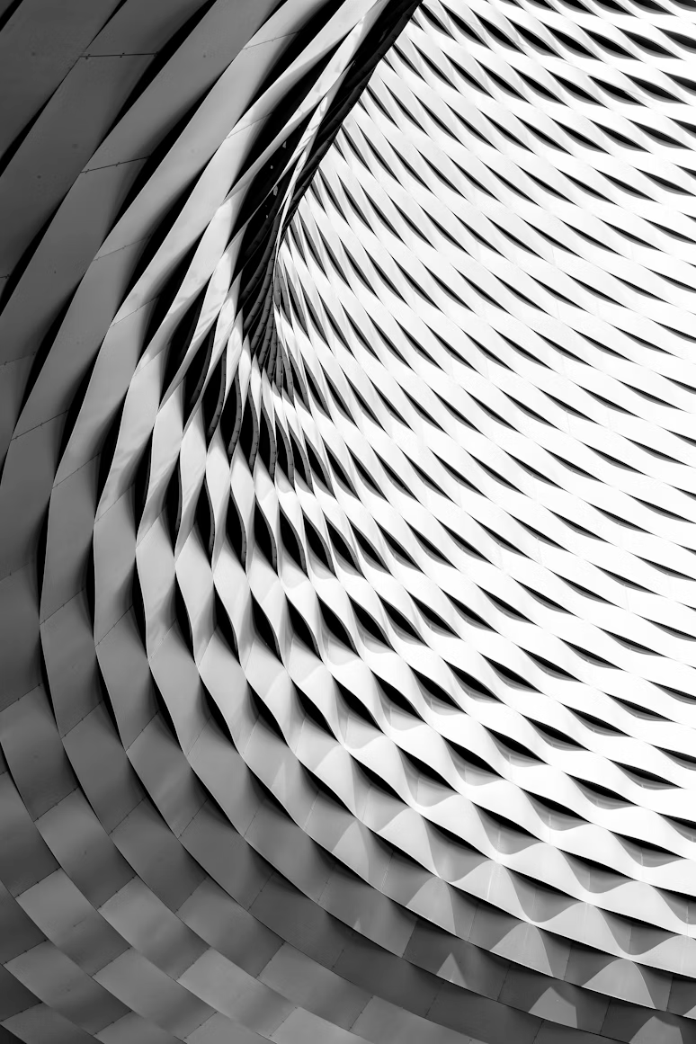 Black and white abstract architectural pattern with twisting, layered triangular shapes.