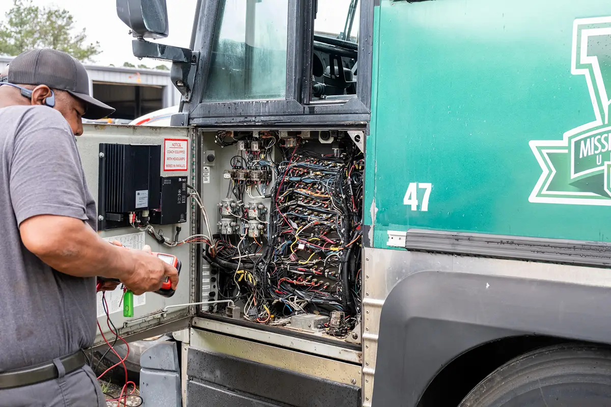Diesel mechanic performing bus repairs
