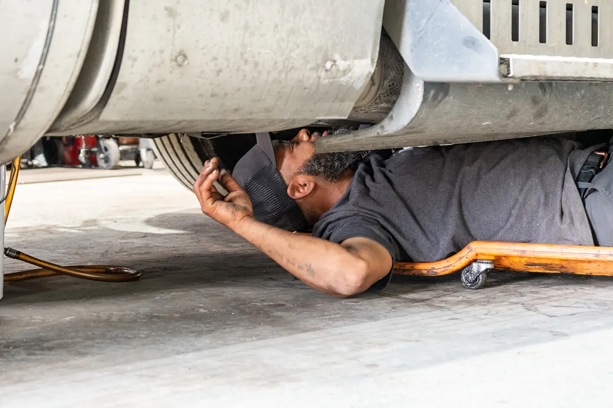 Diesel mechanic performing DOT inspection on truck fleet
