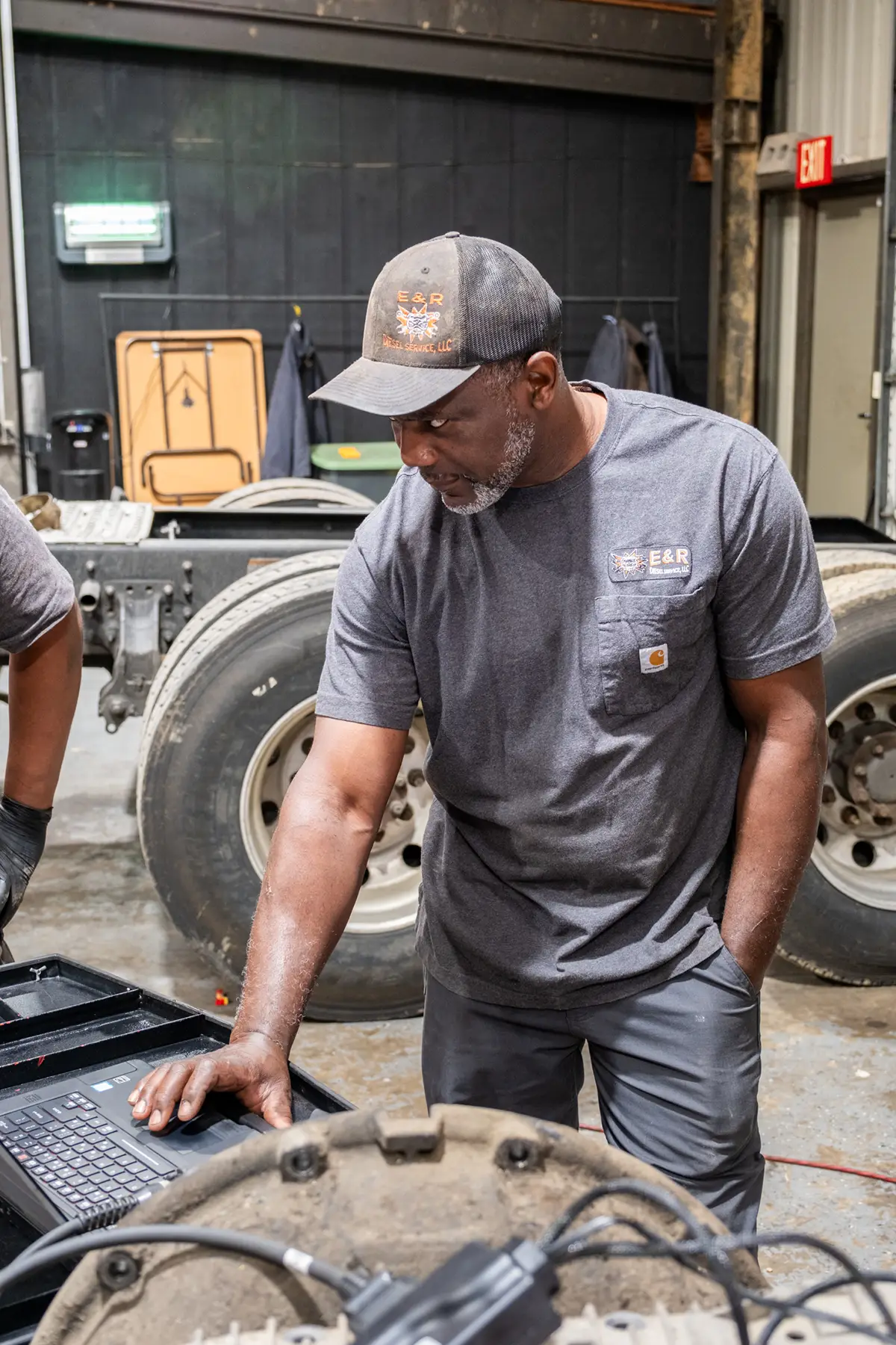 Mechanic performing diagnostic testing on diesel truck
