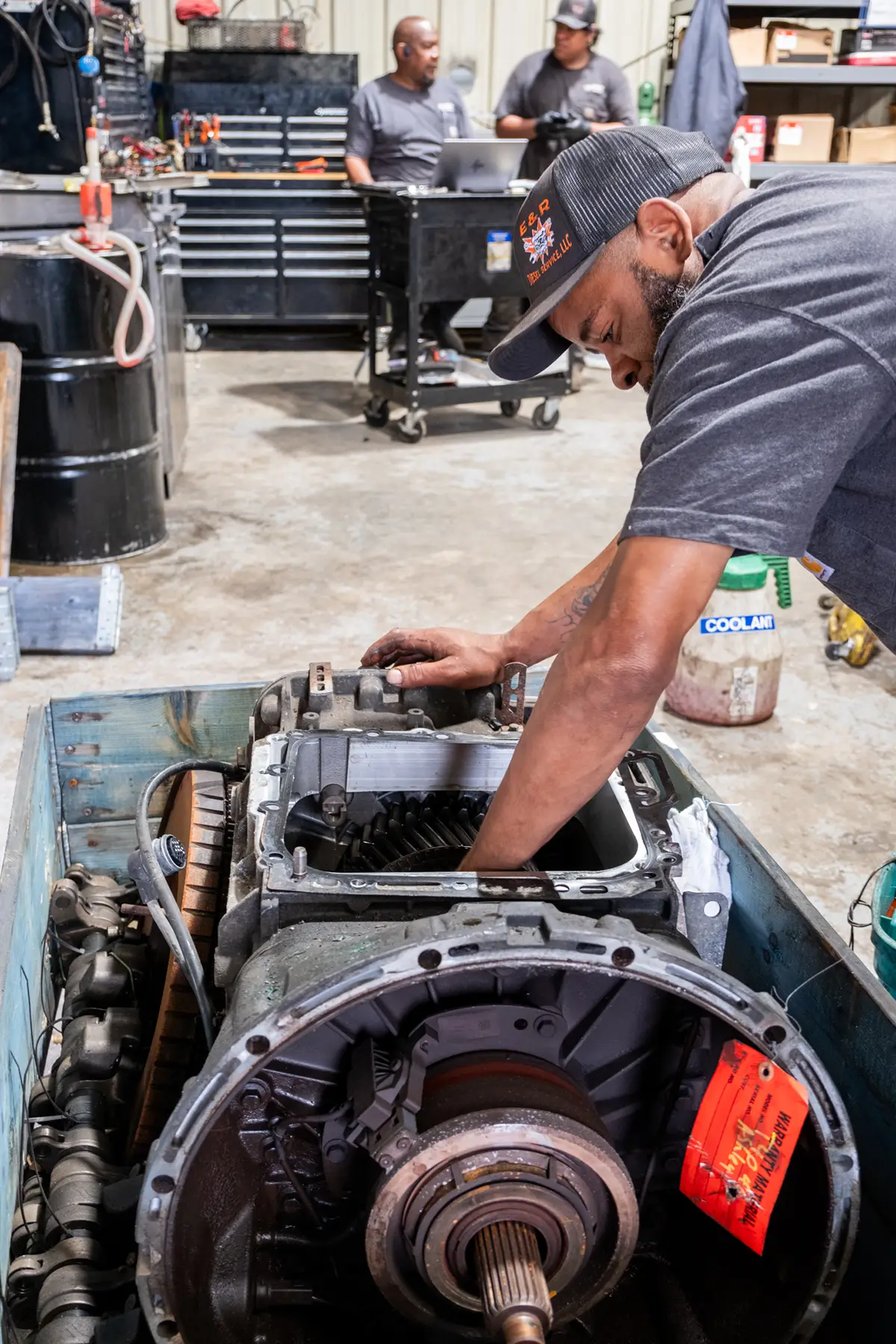 Mechanic performing oil & fluid services on semi truck fleet