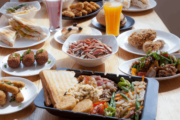 Table of restaurant menu items including sandwiches, fried chicken, croquettes, pancakes, a mixed grill platter, and drinks.