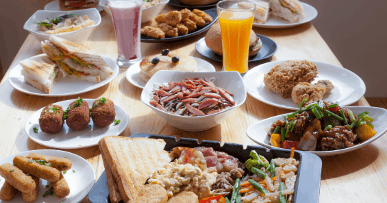 Table of restaurant menu items including sandwiches, fried chicken, croquettes, pancakes, a mixed grill platter, and drinks.