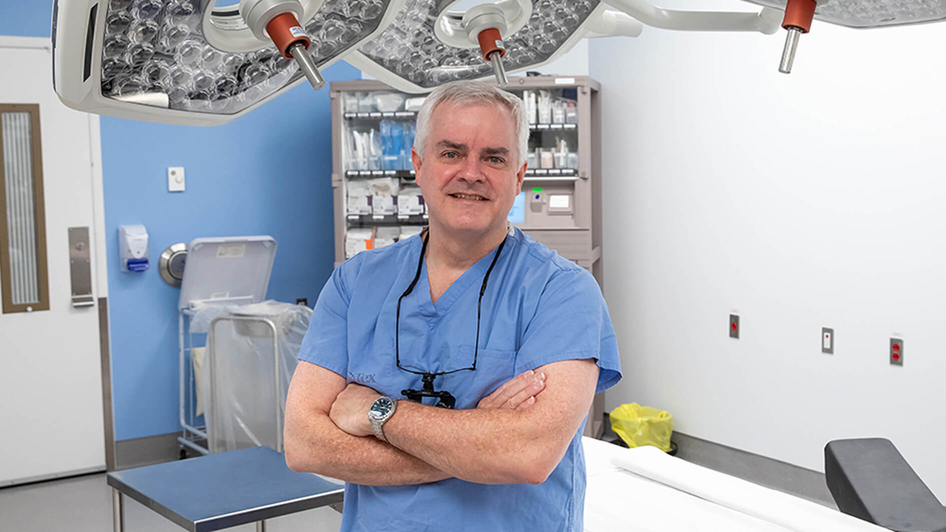 Male smiling surgeon in scrubs in an operating room