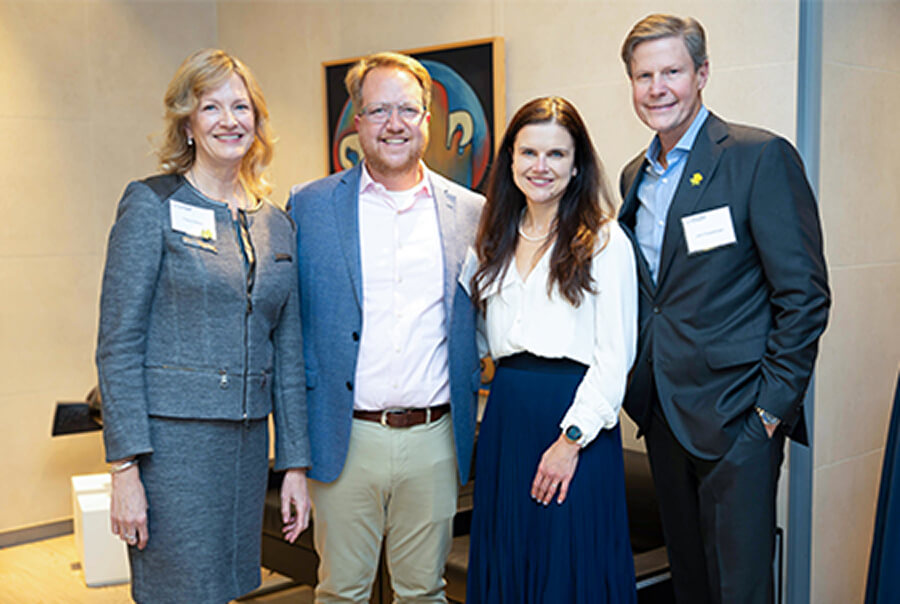 Four smiling individuals at a an event
