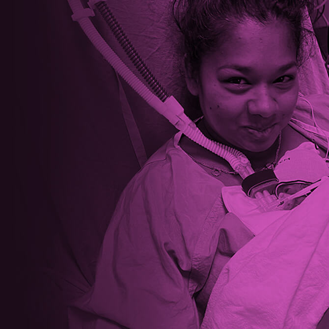 Mother holding premature baby in neonatal intensive care unit