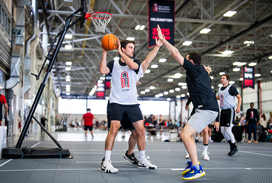 Man defending against another man in an indoor basketball game