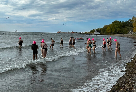 Pink-capped swimmers entering a lake