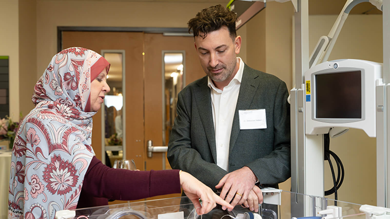 Man and woman looking at a medical incubator at hospital