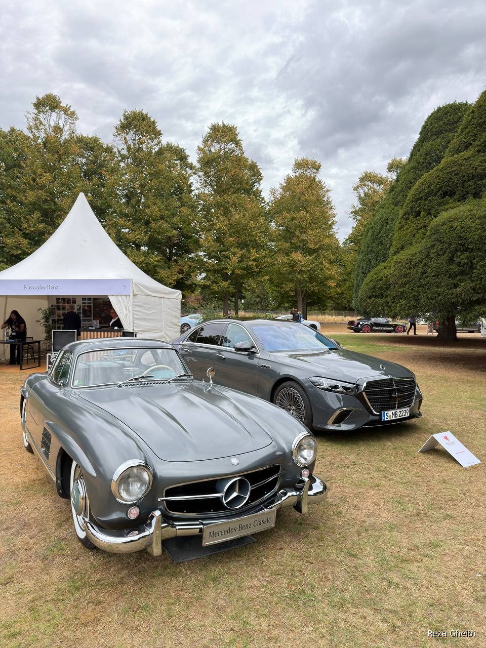 A white 1955 Mercedes-Benz 300 SL beside a modern Mercedes.