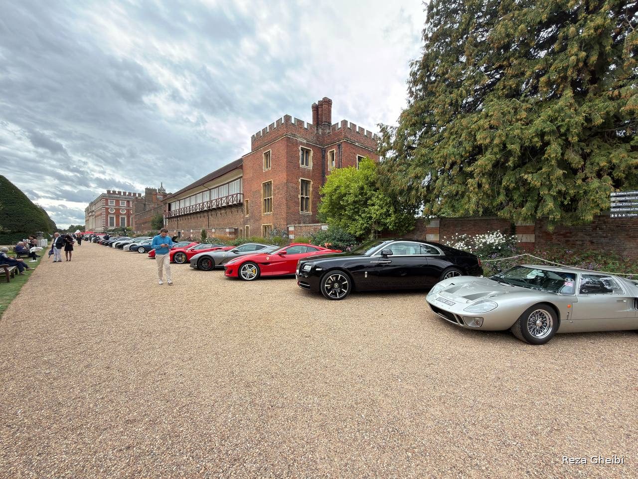A low silver Ford GT40 in the line of supercars beside the palace wall.