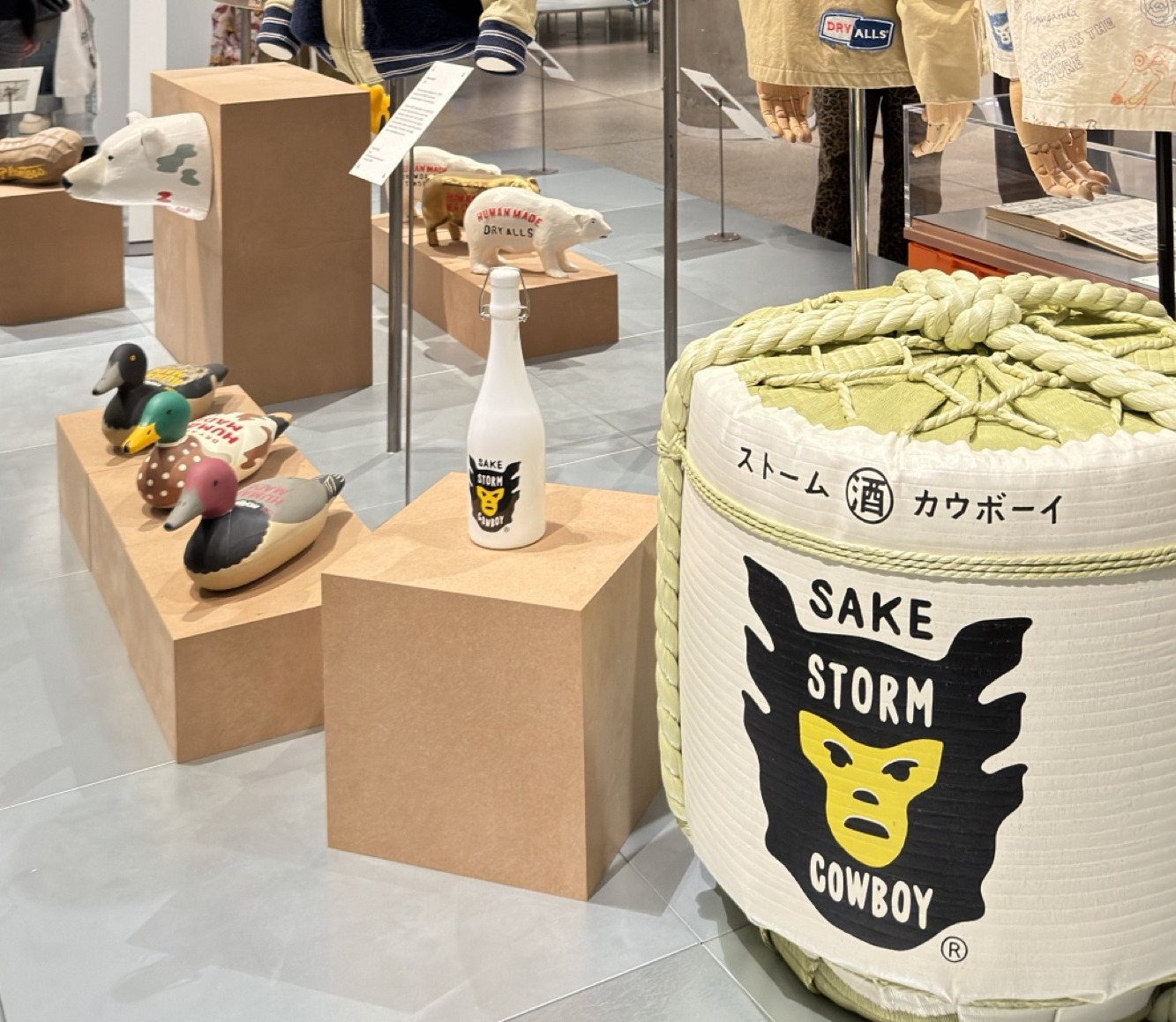 Painted wooden decoy ducks, Human Made polar bears and two Sake Storm Cowboy pieces on plinths in the Human Made room