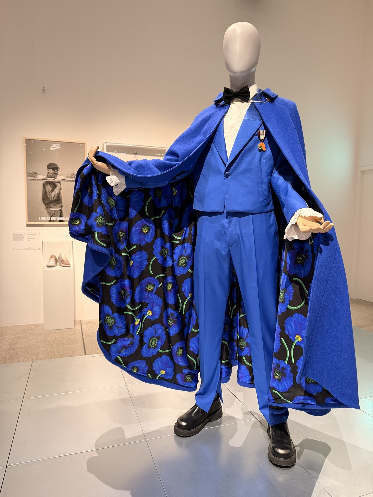 An electric-blue Kenzo tuxedo and cape with poppy-print lining on a faceless mannequin