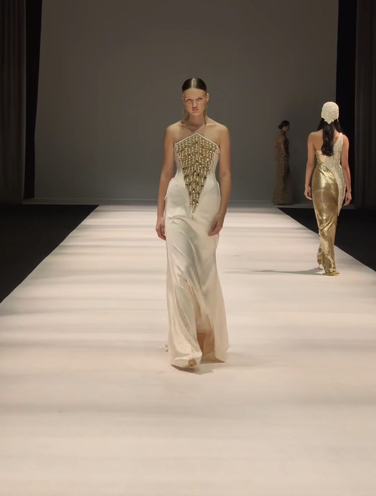 An ivory bias-cut gown with a triangular panel of gold beadwork at the bust