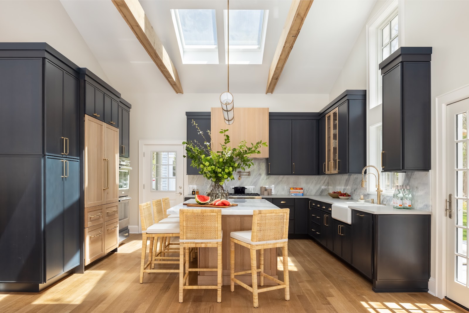East Hampton vaulted kitchen with skylights, exposed beams, navy cabinetry and a natural oak island