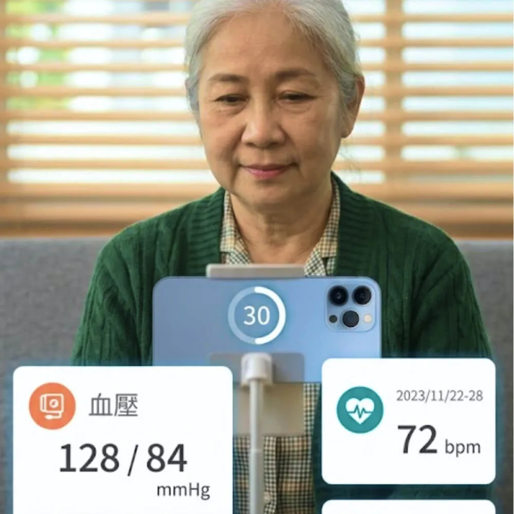 一位年長婦女使用手機,屏幕上顯示血壓128/84和心率72 bpm的健康數據。