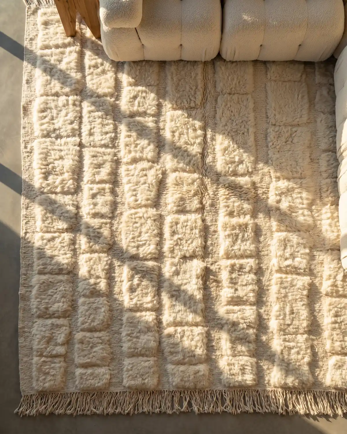 Elio white rectangular block Moroccan rug – overhead detail of dense raised wool pattern and fringe with bouclé sofa