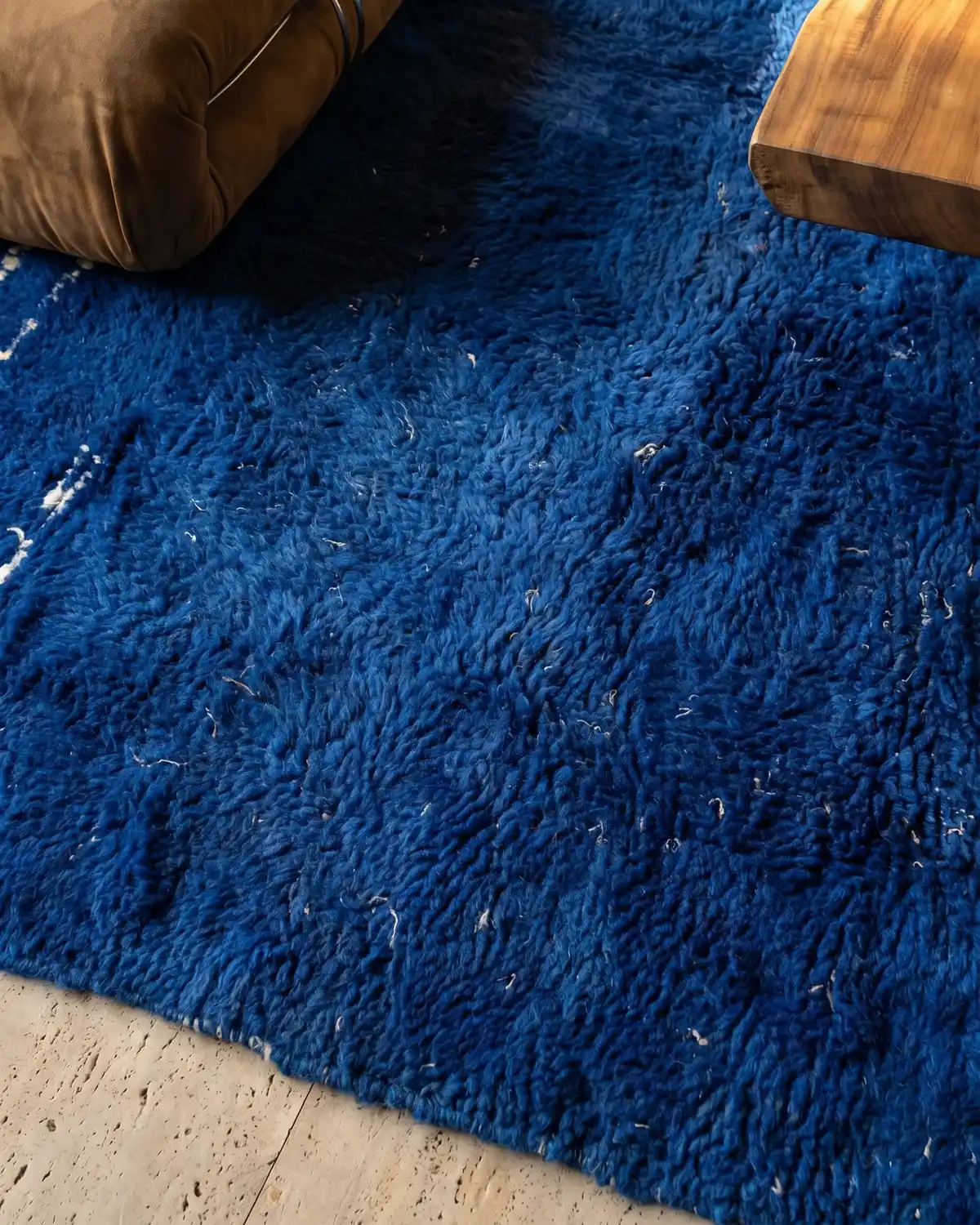 Garance cobalt blue Moroccan rug – close-up of dense royal blue wool texture with leather cushion and wood side table