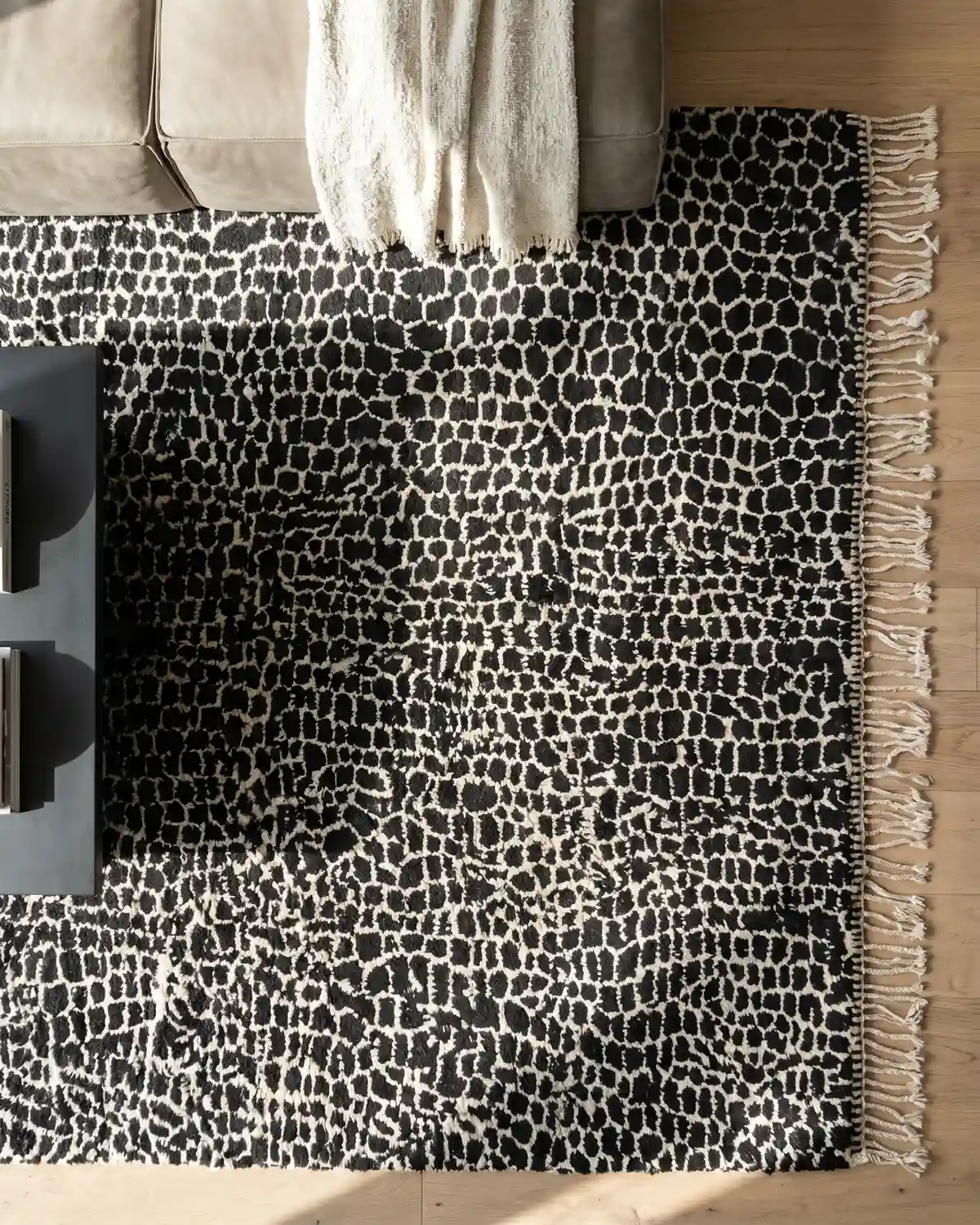Lior leopard-print Moroccan rug – overhead view with fringe detail, styled with a linen sofa