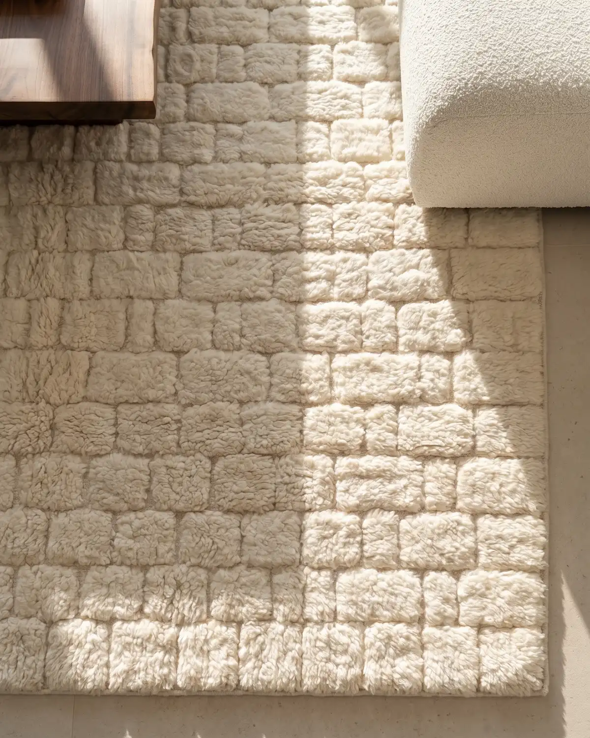 Louis white geometric relief Moroccan rug – overhead detail of dense rectangular wool blocks in natural sunlight with wood coffee table