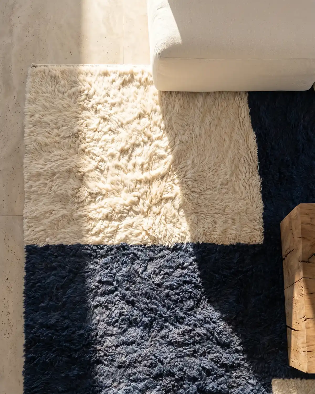 Lunama navy and ivory color block Moroccan rug – overhead detail of blue and white wool blocks with white sofa and wood side table