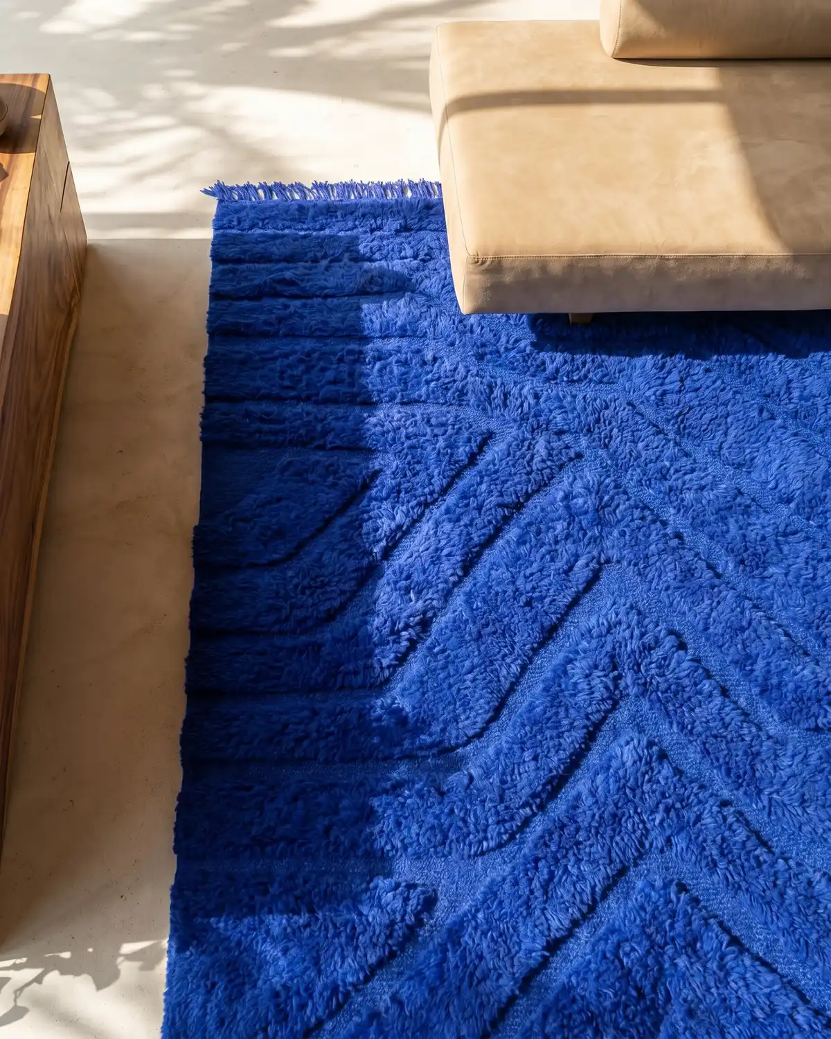 Mila cobalt blue sculptural Moroccan rug – overhead detail of geometric relief pattern and fringe with leather sofa and wood side table