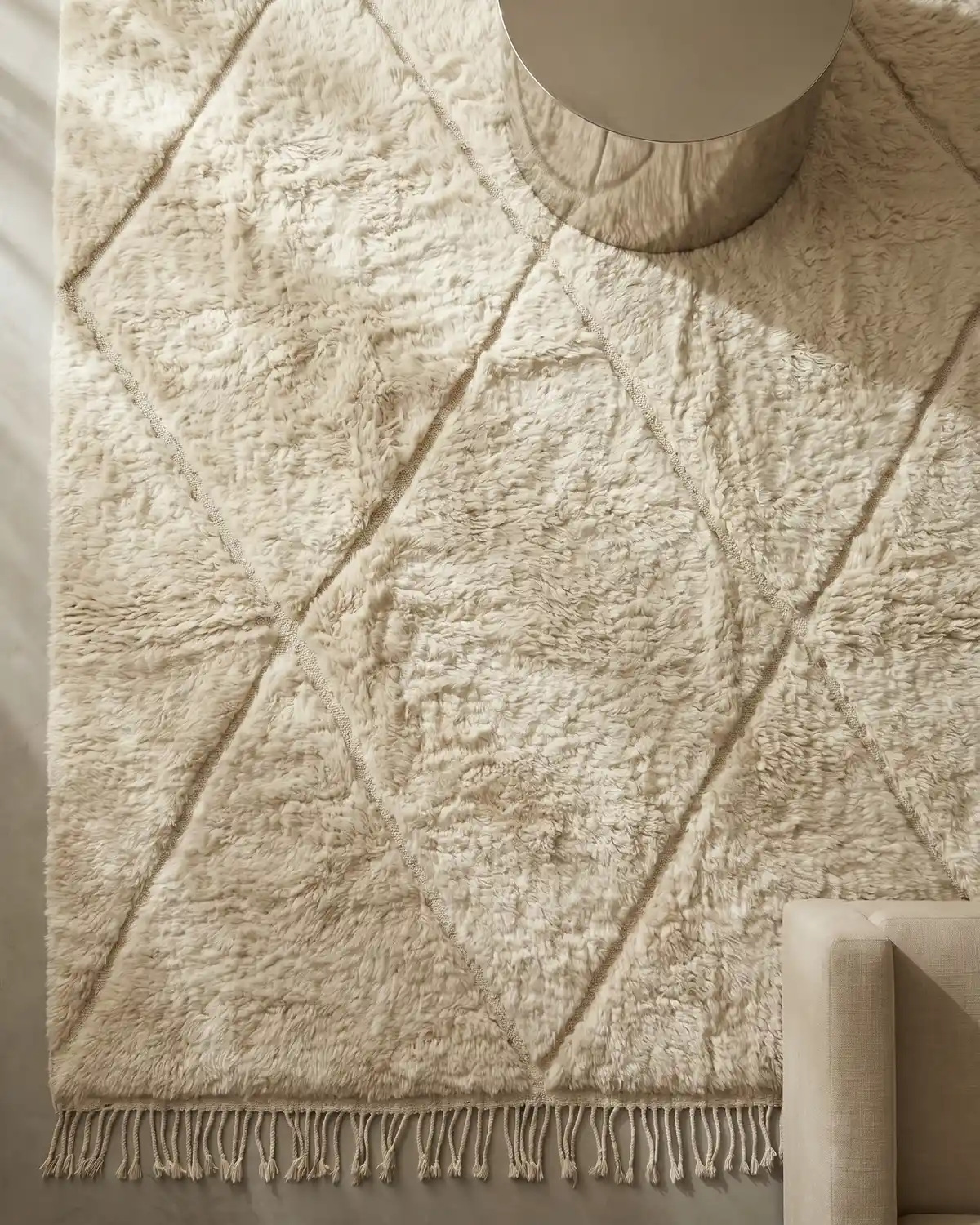 Lou Beni Ourain rug detail – overhead close-up of ivory diamond pattern and twisted fringe with soft natural wool texture