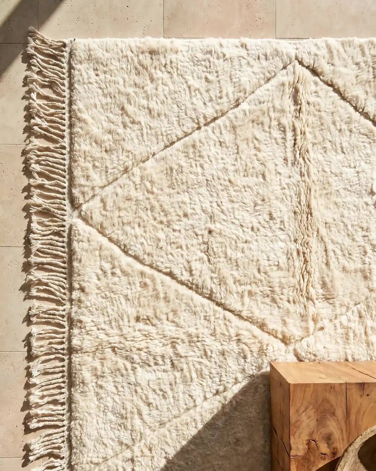 Lou fluffy white Moroccan rug – overhead detail of diamond line pattern and fringe on travertine floor