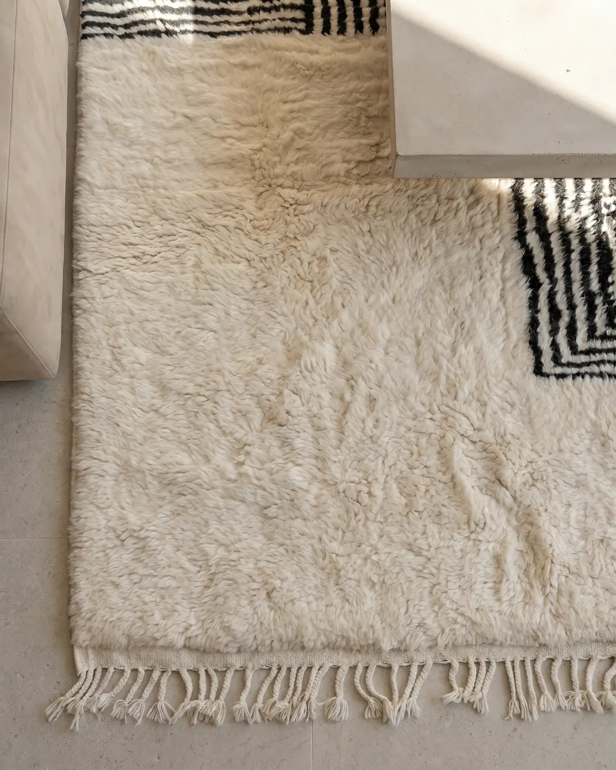 Tipi geometric line Moroccan rug – overhead detail of ivory wool surface and black striped block pattern with fringe
