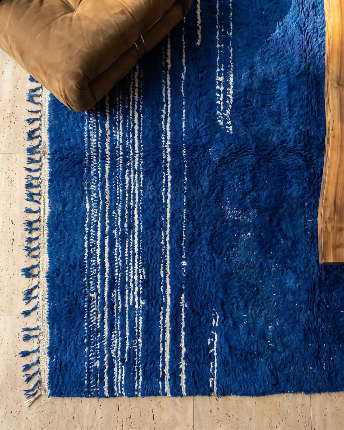 Garance cobalt blue Moroccan rug – close-up of dense royal blue wool texture with leather cushion and wood side table