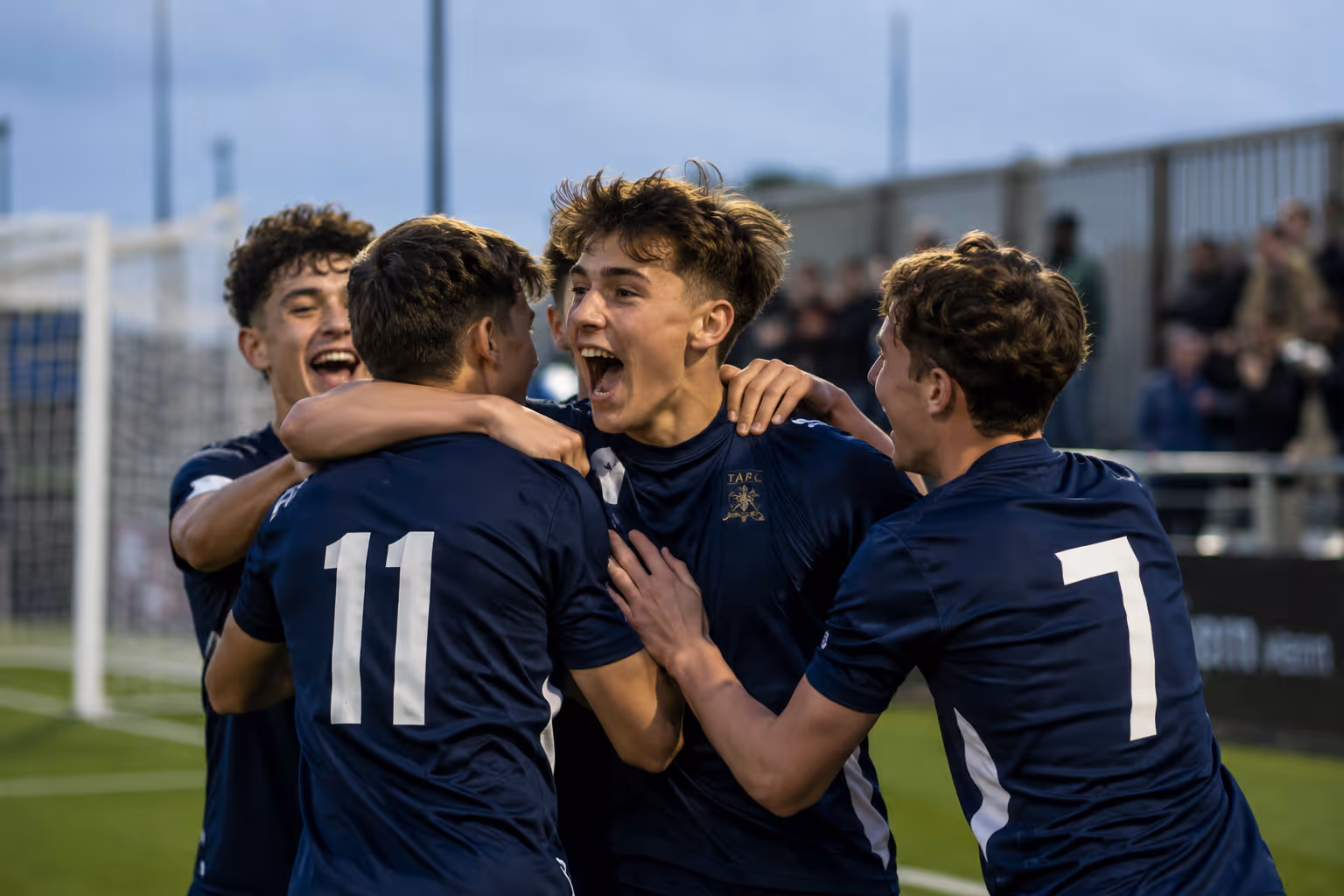 A goal being celebrated at a grassroots football match.