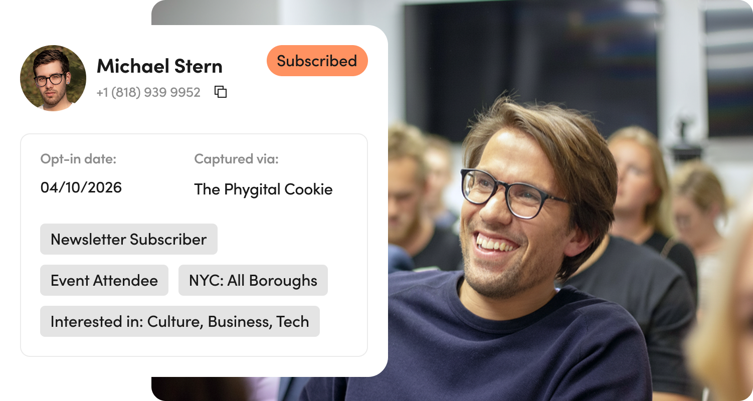 Smiling man with glasses in audience wearing navy shirt, with contact card overlay showing Michael Stern's details and subscription status.