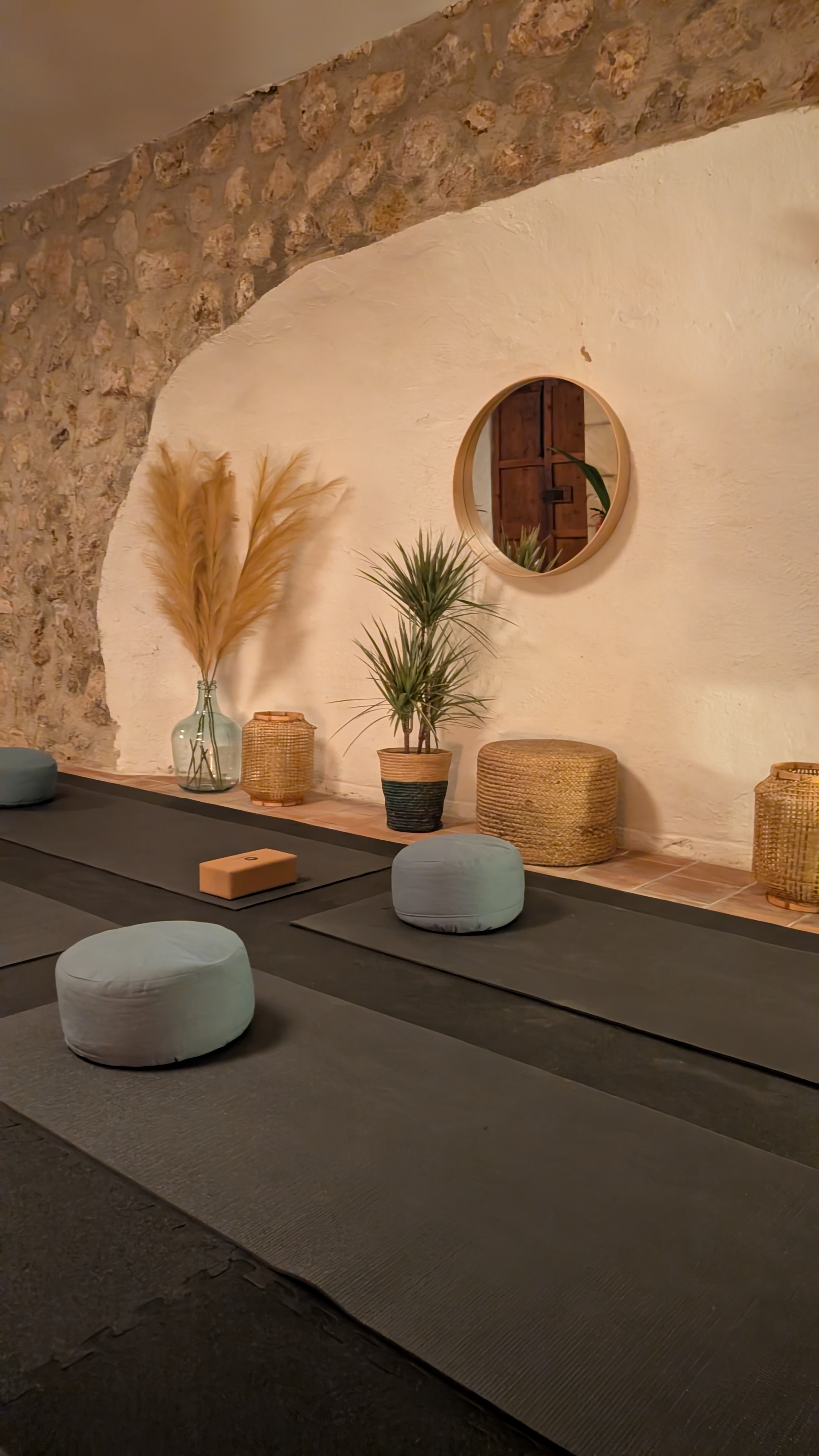 Indoor yoga shala at Finca Higo with yoga mats, meditation cushions, and plants in a warm, charming room.