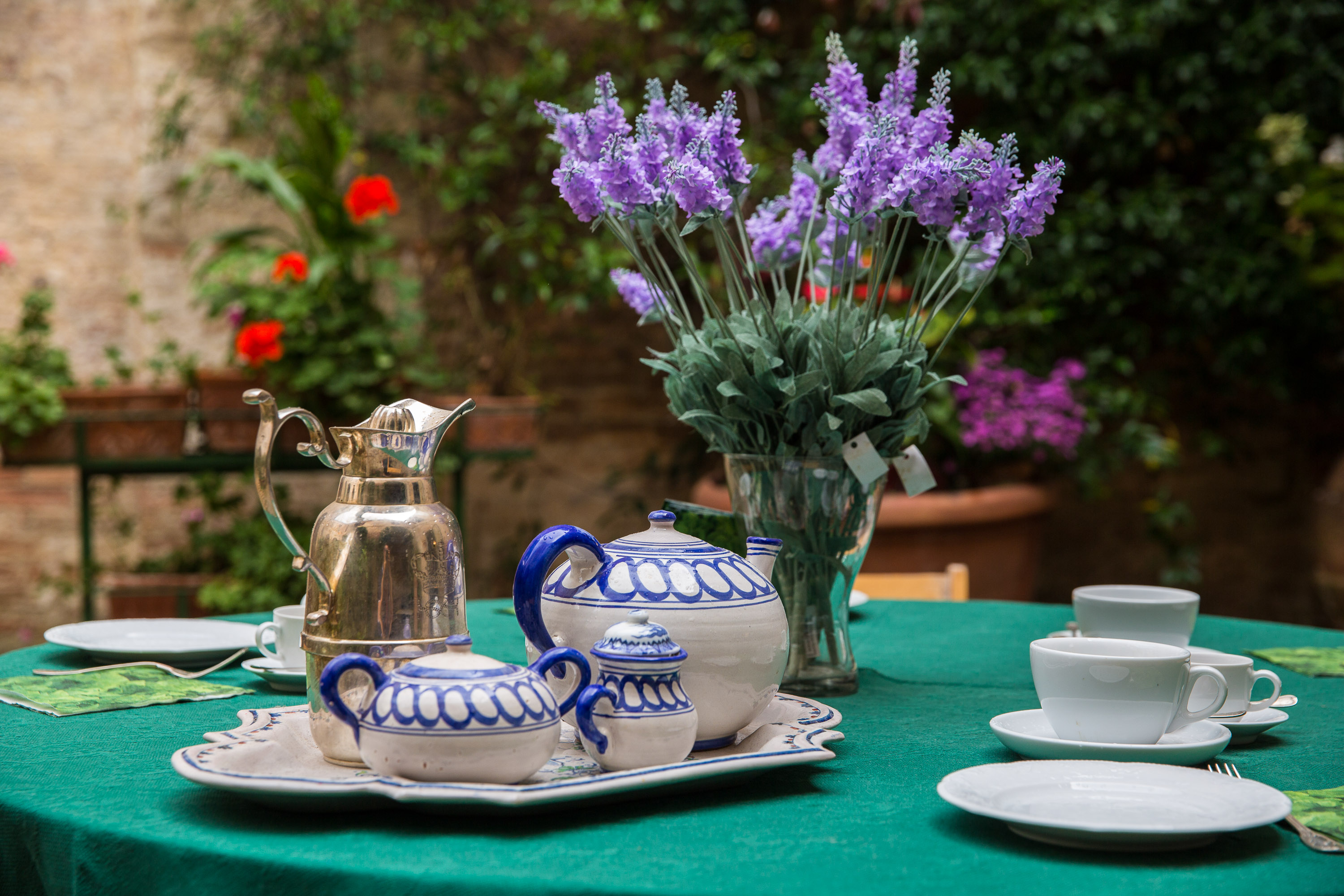 Elegant outdoor tea setting with lavender and ceramic tableware at Castello Higo, a luxury yoga and Pilates retreat in Tuscany, Italy