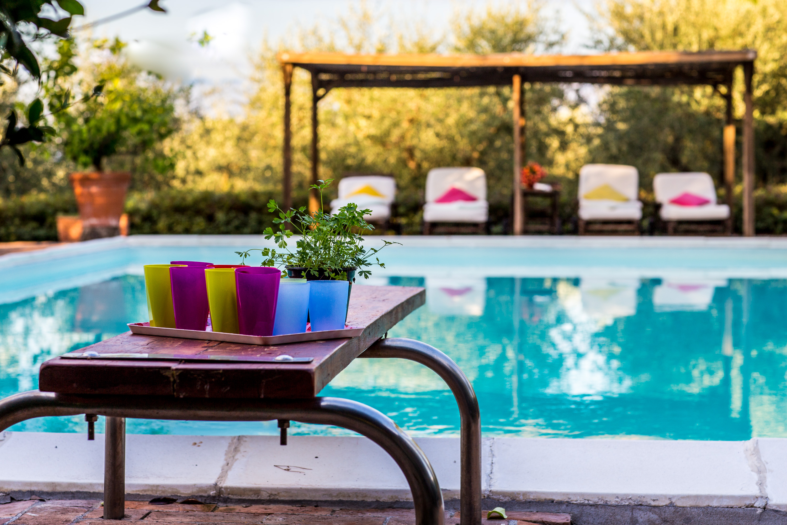 Relaxing poolside setting with refreshments and sun loungers at Castello Higo, a luxury yoga and wellness retreat in Tuscany, Italy