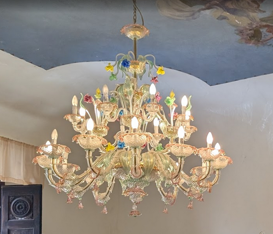 Elegant chandelier in a historic Tuscan interior at Castello Higo, a luxury yoga and Pilates retreat center in Tuscany