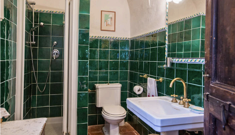 Traditional Italian bathroom with green tiles and classic design at Castello Higo, a luxury yoga and Pilates retreat in Tuscany